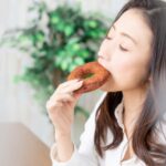 ドーナツをかじる女性