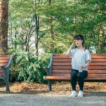 暑くて公園のベンチで休む女性